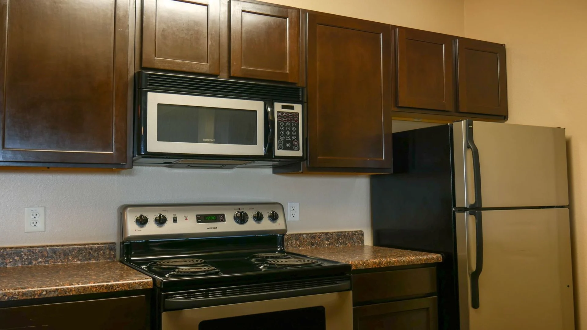 a kitchen with stainless steel appliances and wood cabinets at The Anatole on MacArthur North