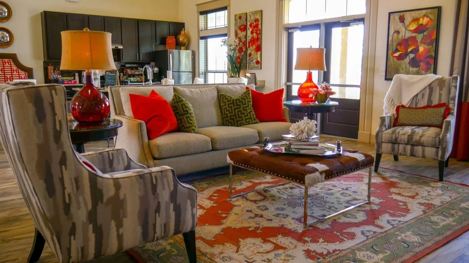 a living room with red and orange accents at The Anatole on MacArthur North