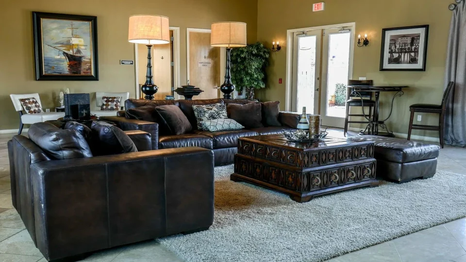 a living room with leather furniture and a large tv at The Anatole on MacArthur North