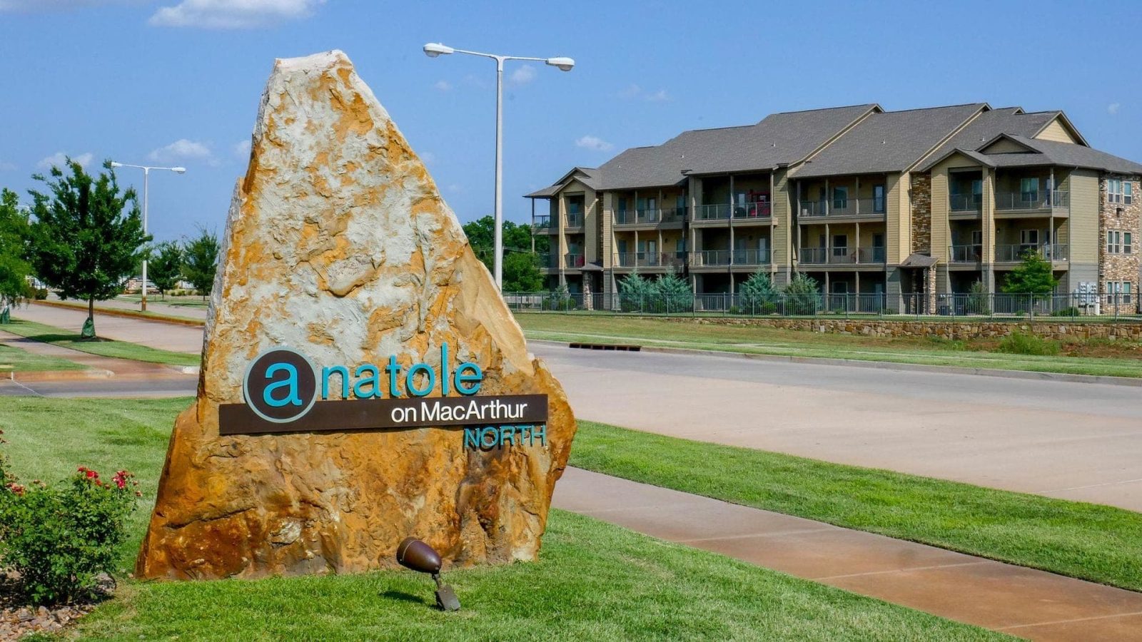 the sign for the apartment complex is in front of a building at The Anatole on MacArthur North