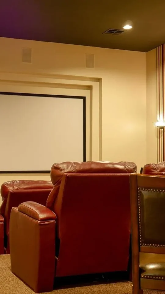 a home theater with leather chairs and a screen at The Anatole on MacArthur North