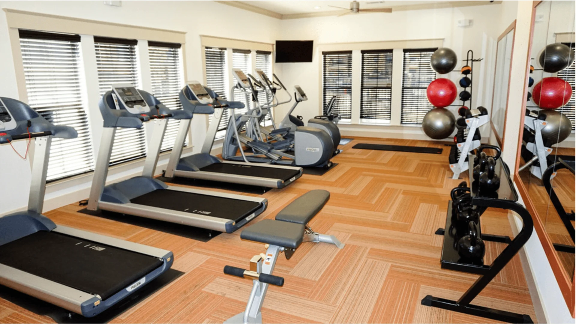 a gym room with tread machines and exercise equipment at The Anatole on MacArthur North