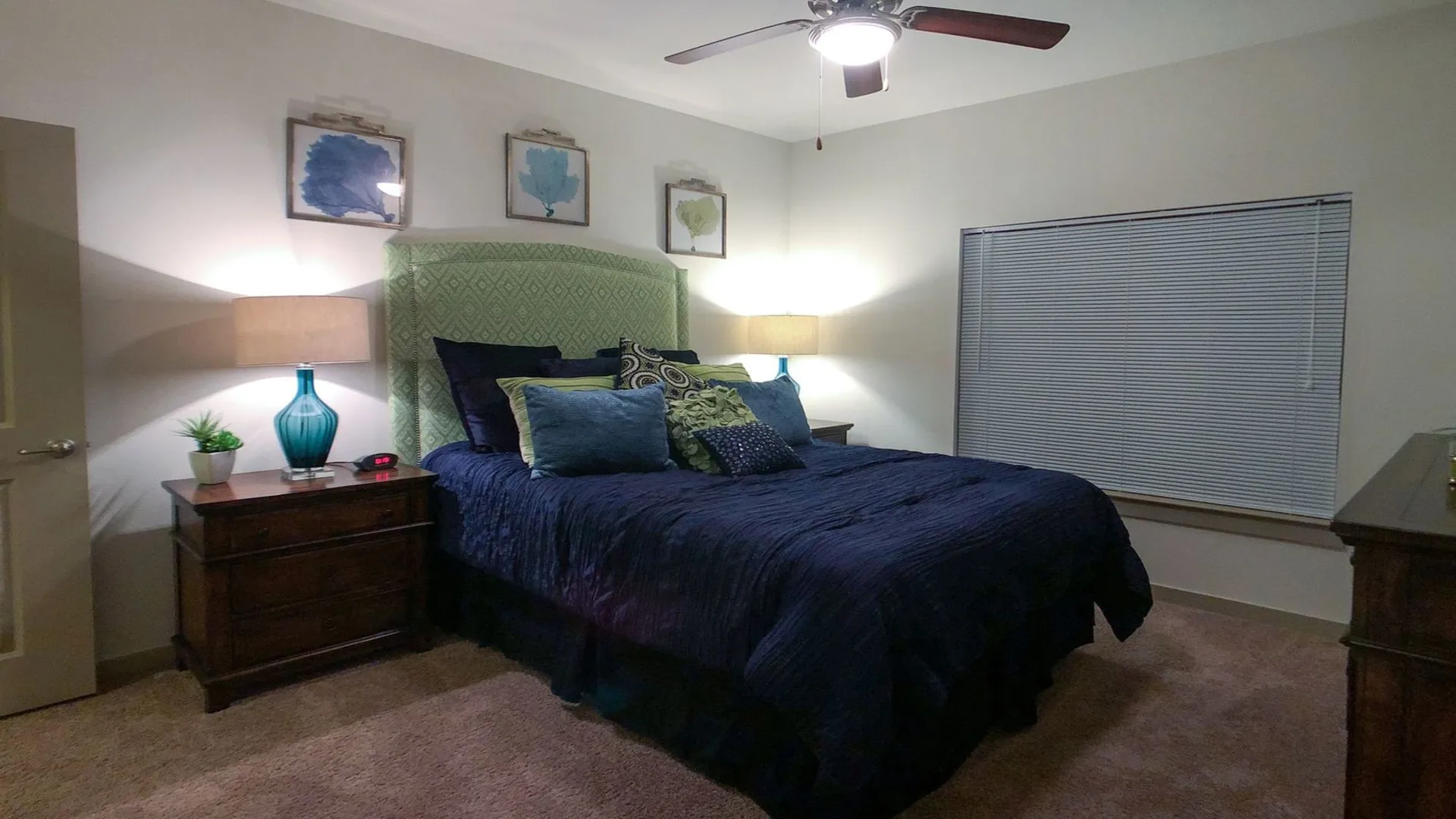 a bedroom with a blue bed and a ceiling fan at The Anatole on MacArthur North